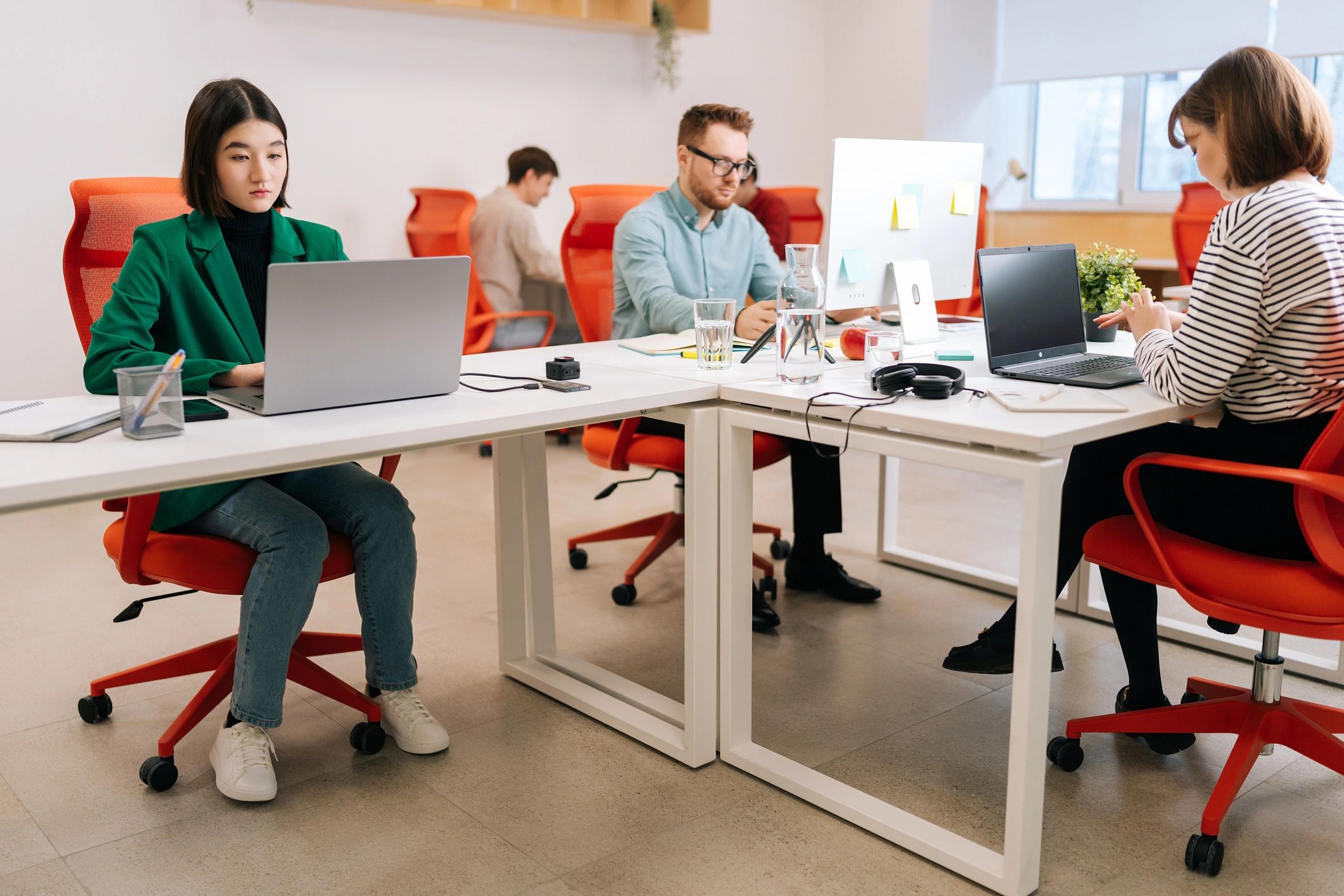 Team collaborating in a modern office with laptops