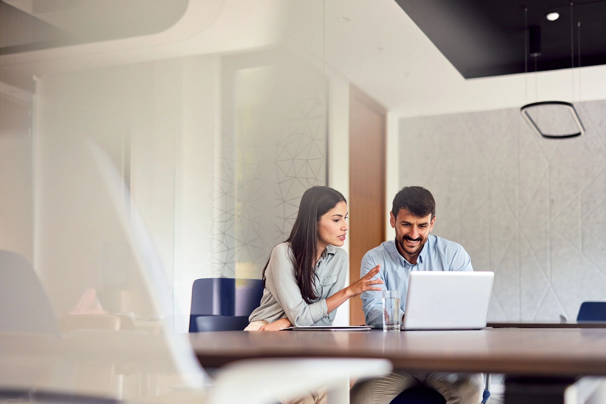 IT consultants collaborating on a laptop in a modern office